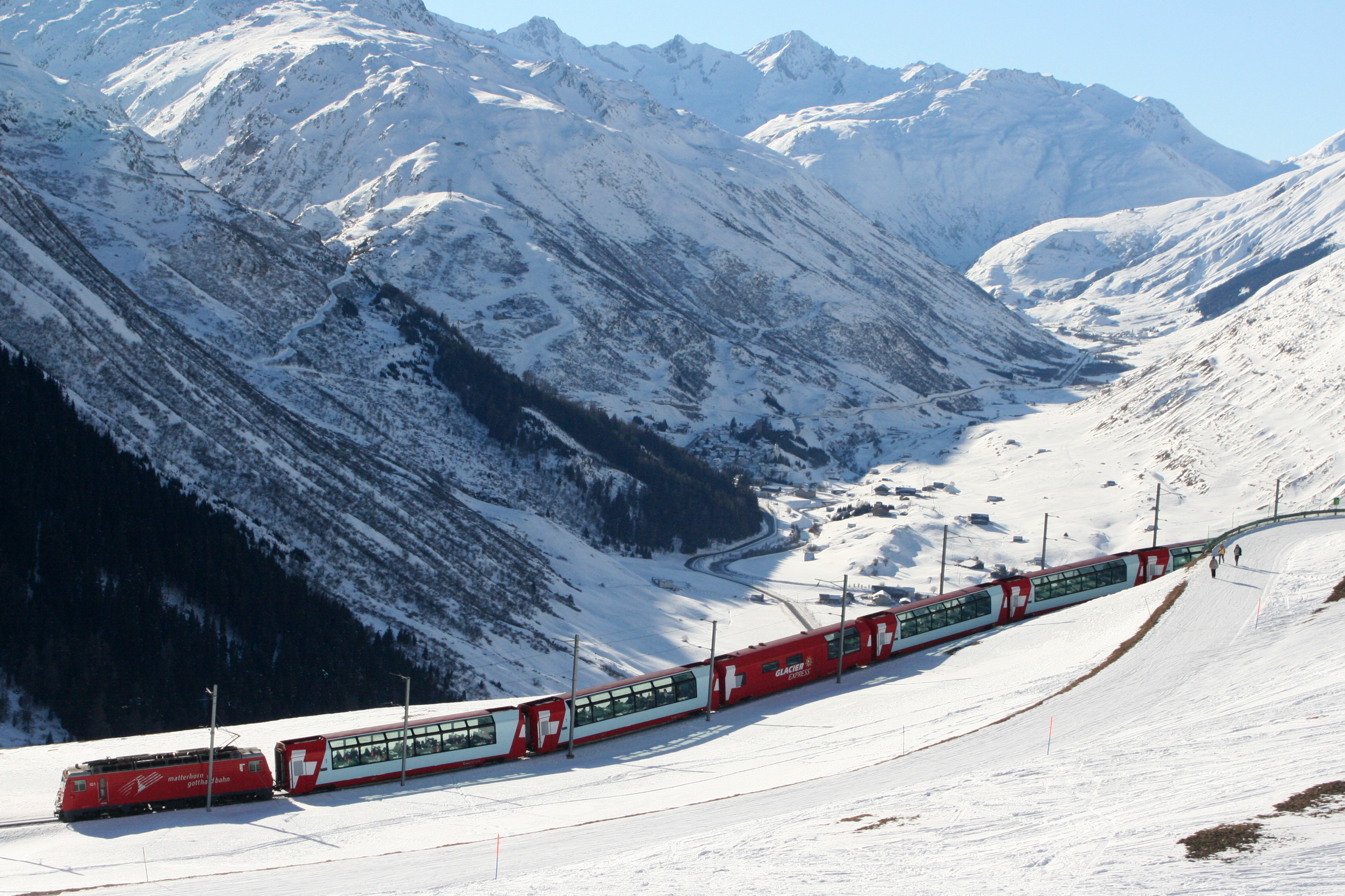 Der Berninaexpres mit schneereicher Landschaft und blauem Himmel